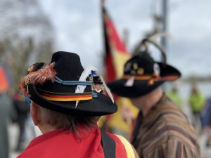 Zwei Männer tragen Heckerhüte und Schärpen in Schwarz-Rot-Gold.