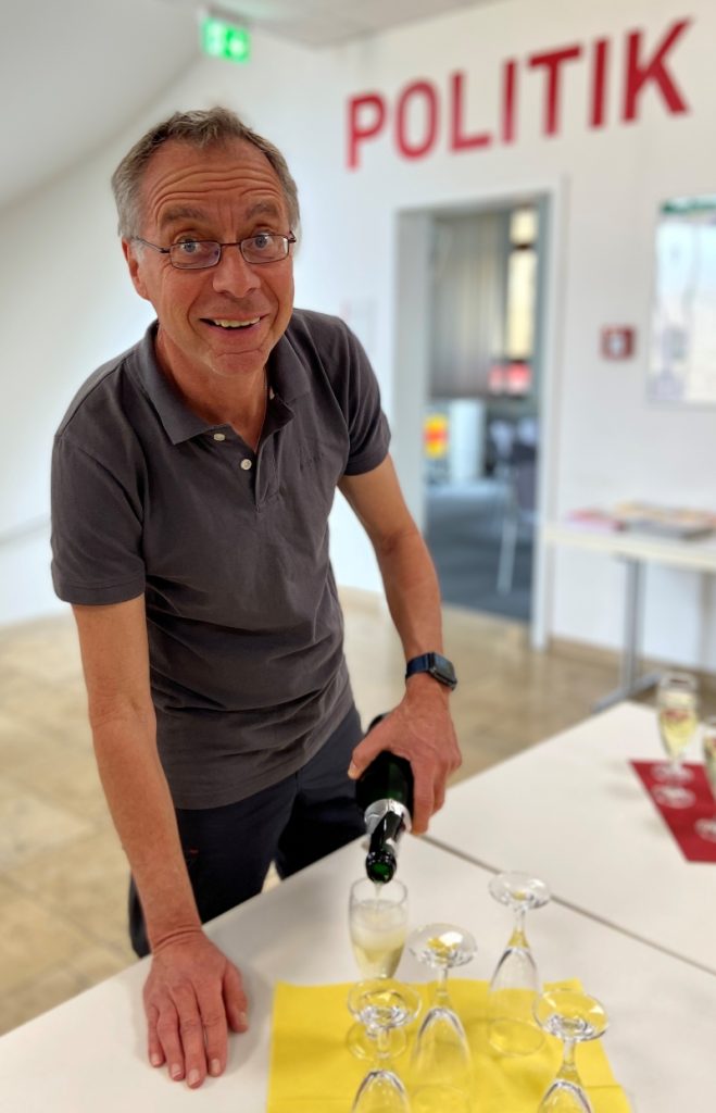 Ein Mann schenkt Sekt ein.