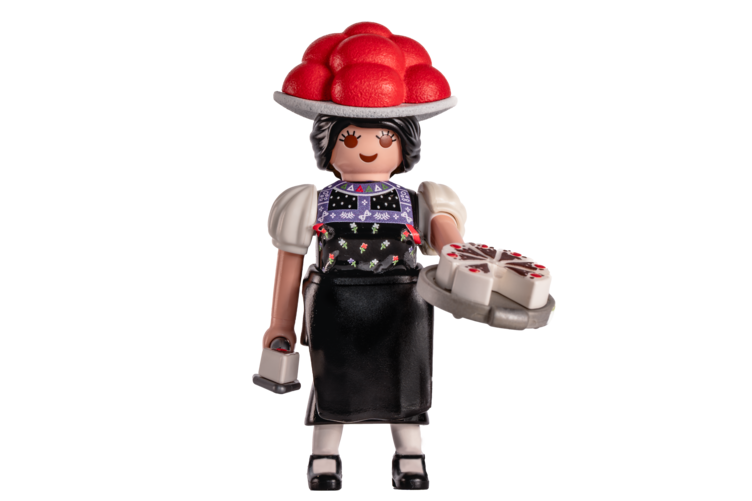 Die Schwarzwald-Marie als Playmobilfigur mit Schwarzwälderkrischtorte in der Hand, Bollenhut auf dem Haupt und im Trachtenkleid.
